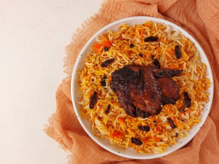 Photo for Nasi kebuli. it is an Indonesian variation ofpilaf. It consists of rice cooked ingoat meatbroth,goat milk, andclarified butter. Completed with chicken breast. Served on white plate. Savory taste - Royalty Free Image