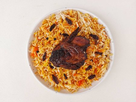 Photo for Nasi kebuli. it is an Indonesian variation ofpilaf. It consists of rice cooked ingoat meatbroth,goat milk, andclarified butter. Completed with chicken breast. Served on white plate. Savory taste - Royalty Free Image