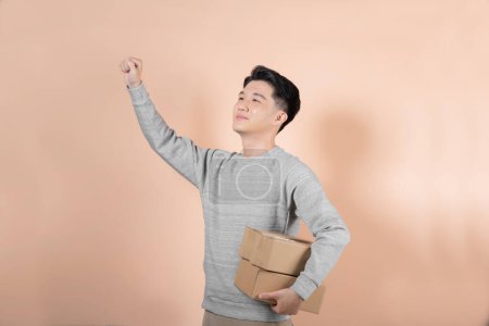 Photo for Handsome man in a gray hoodie shirt with parcel boxes - Royalty Free Image