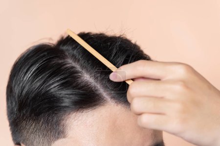 Téléchargez les photos : Jeune homme peigne ses cheveux - en image libre de droit