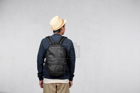 Foto de Back view of young man tourist in straw hat with backpack isolated on white background - Imagen libre de derechos