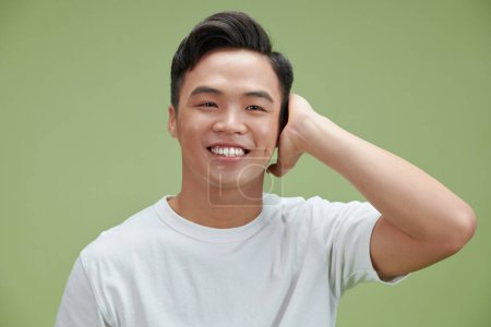 Photo for Happy handsome smiling man touching his hair - Royalty Free Image
