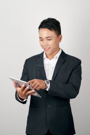 Photo for A handsome young businessman using a digital tablet on white background. - Royalty Free Image