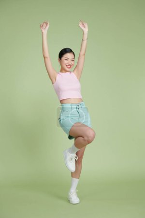 Téléchargez les photos : Portrait complet de incroyable asiatique fille posant avec les mains en l'air - en image libre de droit