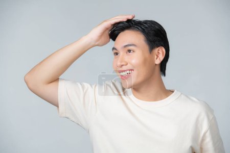 Téléchargez les photos : Bel homme toucher ses cheveux fermer studio portrait sur fond blanc - en image libre de droit