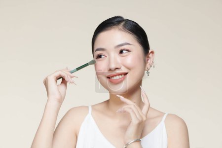 Foto de Joven bonita asiático señora hacer maquillaje con cepillo para ojos aislado - Imagen libre de derechos