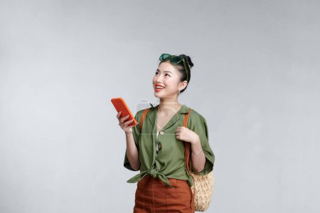 Téléchargez les photos : Heureuse jeune femme touristique asiatique en utilisant smartphone - en image libre de droit