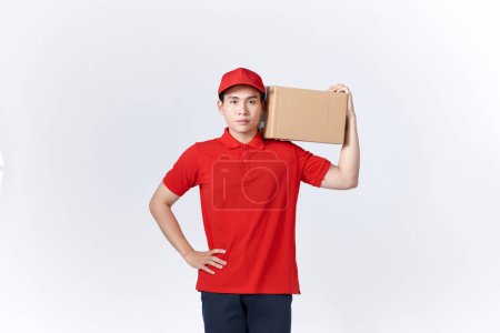 Photo for Young asian man holding delivery package smiling happy and positive - Royalty Free Image