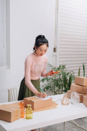 Photo for Female online store preparing an order for shipping in a warehouse - Royalty Free Image