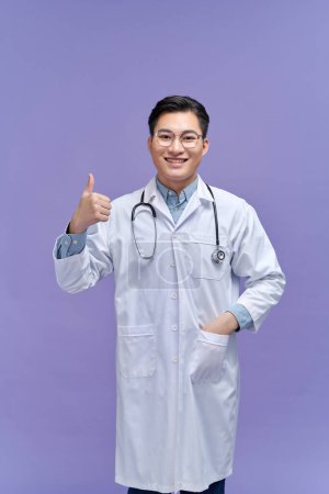 Photo for Portrait of a friendly doctor smiling giving thumbs up - Royalty Free Image