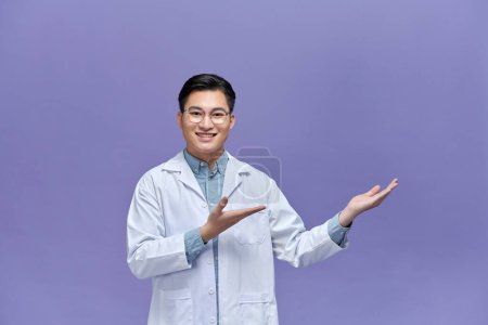 Photo for Confident young doctor showing something with his hand - Royalty Free Image
