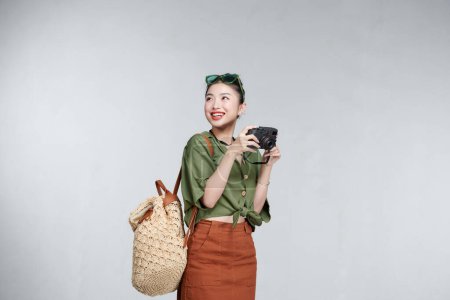Téléchargez les photos : Heureux asiatique femme voyageur debout et tenant caméra - en image libre de droit