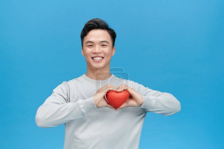 Téléchargez les photos : Jeune homme tenant un jouet en forme de coeur rouge - en image libre de droit