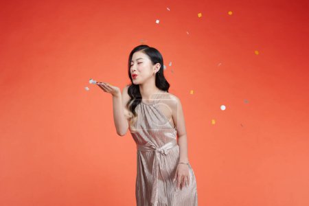 Foto de Hermosa glamour asiático chica golpes confetti - Imagen libre de derechos