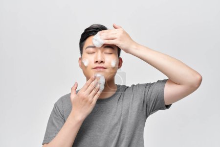 Foto de Joven lavándose la cara con espuma limpiadora, concepto de cuidado de la piel de los hombres - Imagen libre de derechos