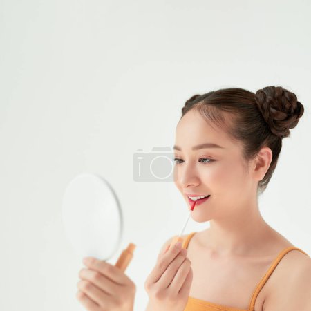 Photo for Portrait of beautiful woman applying lipstick using lip concealer brush - Royalty Free Image