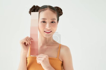 Foto de Mujer belleza asiática mantenga la escala de color con protección solar UV o protector solar en el fondo blanco - Imagen libre de derechos