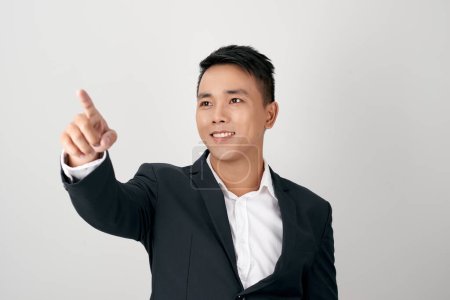 Téléchargez les photos : Jeune homme avec doigt appuyant numériquement sur le bouton dans l'air - en image libre de droit