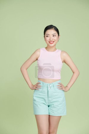 Photo for Charming cute young woman smiling and posing in tank top and shorts - Royalty Free Image