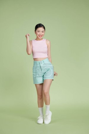 Foto de Cuerpo completo de joven atractiva chica asiática sobre fondo verde - Imagen libre de derechos