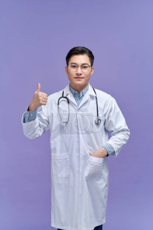 Photo for Doctor man standing over isolated purple background doing happy thumbs up gesture with hand - Royalty Free Image