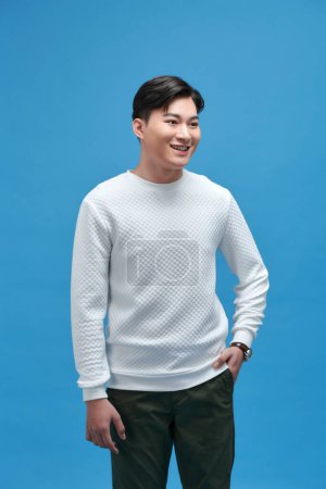 Téléchargez les photos : Attrayant élégant sourire jeune homme portant un t-shirt blanc posant dans le studio - en image libre de droit