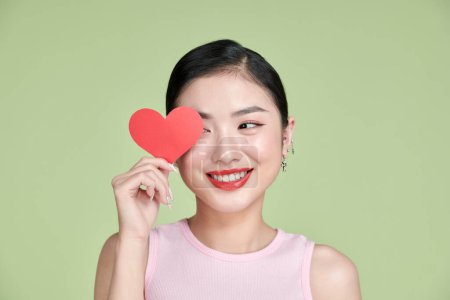 Foto de Bonita mujer asiática con sonrisa dentada con corazón rojo - Imagen libre de derechos