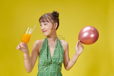 Photo for Cute lady holding glass with tropical beverage in hand isolated on bright vivid background - Royalty Free Image