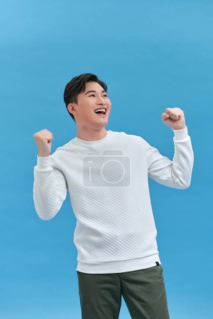 Photo for Joyful man holding his hands in the fists - Royalty Free Image