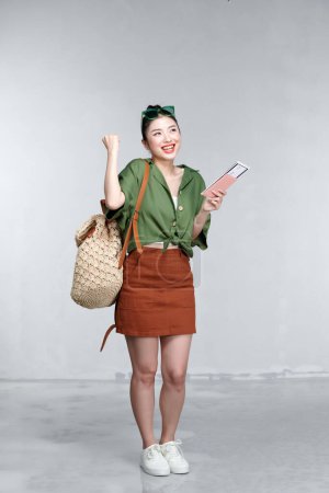 Téléchargez les photos : Femme touristique heureuse excitée avec passeport, billet isolé sur fond blanc - en image libre de droit