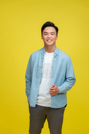 Téléchargez les photos : Jeune homme asiatique posant sur fond jaune - en image libre de droit