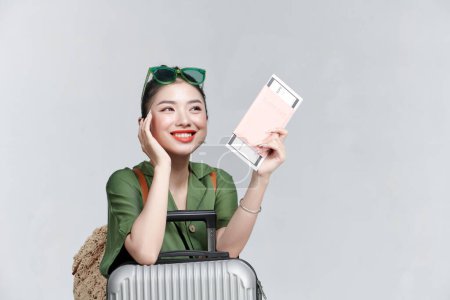 Foto de Imagen de una joven y excitada turista guapa con una maleta con pasaporte y billete - Imagen libre de derechos