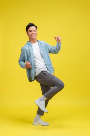 Photo for Portrait of young male cheerful confident and excited jump in air and smile at studio. - Royalty Free Image