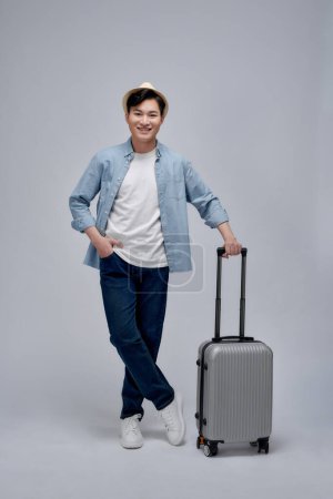 Téléchargez les photos : Touriste masculin avec valise marche aller en vacances publicité offre de voyage - en image libre de droit