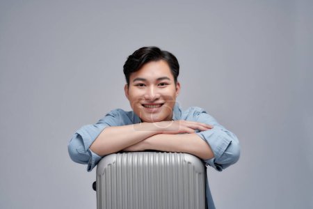 Téléchargez les photos : Homme heureux avec valise qui attend un voyage d'été isolé sur fond blanc. - en image libre de droit