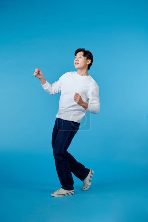 Photo for Full body image of asian man posing on blue background - Royalty Free Image