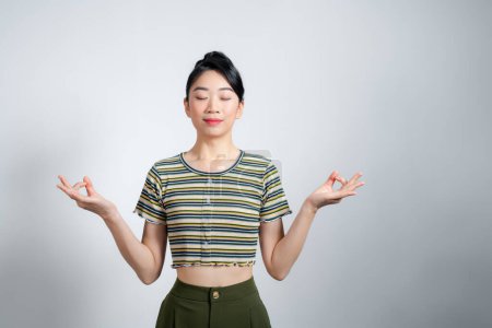 Téléchargez les photos : Attrayant asiatique femme avec fermer les yeux tenir la main dans zen mudra geste - en image libre de droit