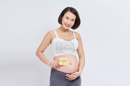 Photo for Pregnant woman with stick note on her belly - Royalty Free Image