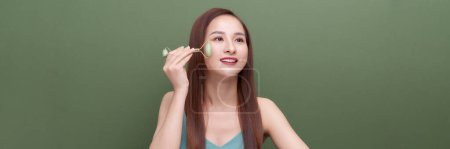 Photo for Panorama of asian girl uses beauty gua sha jade quartz roller. - Royalty Free Image