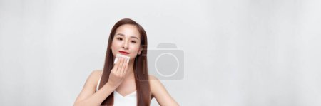 Téléchargez les photos : Panorama avec femme asiatique enlever l'huile du visage à l'aide de papiers buvards. - en image libre de droit