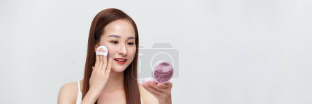 Téléchargez les photos : Glamour belle asiatique femelle appliquant de la poudre de coussin pour le maquillage du visage concept sur bannière - en image libre de droit