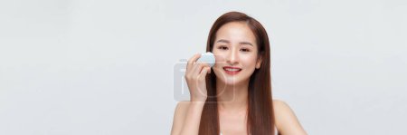 Téléchargez les photos : Belle jeune femme asiatique appliquant le maquillage en utilisant l'éponge mélangeur de beauté. - en image libre de droit