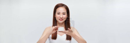 Téléchargez les photos : Heureux jeune asiatique femme tenant pot de crème sur blanc bannière - en image libre de droit