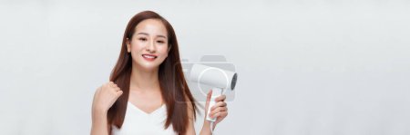 Photo for Banner of beautiful smiling asian girl with long straight hair using hairdryer. - Royalty Free Image
