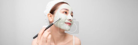 Téléchargez les photos : Belle femme asiatique ayant masque facial en argile appliquer par esthéticienne. - en image libre de droit