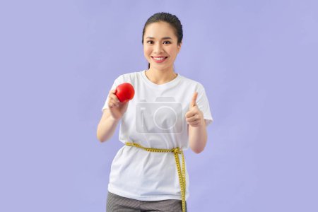 Photo for Healthy female body with apple and measuring tape - Royalty Free Image