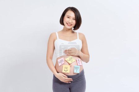 Foto de Vientre de una joven embarazada con pegatinas y una pregunta (concepto de niño o niña)) - Imagen libre de derechos