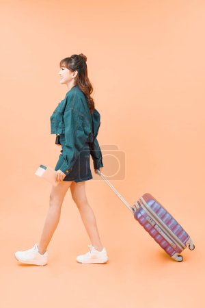 Téléchargez les photos : Fille avec une valise voyageant sur fond de couleur - en image libre de droit