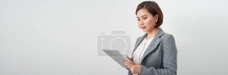 Téléchargez les photos : Belle jeune femme d'affaires asiatique tenant presse-papiers sur fond de bannière blanche - en image libre de droit