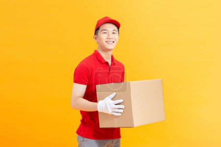 Photo for Courier pick-up package from client, shipping box isolated over yellow background - Royalty Free Image